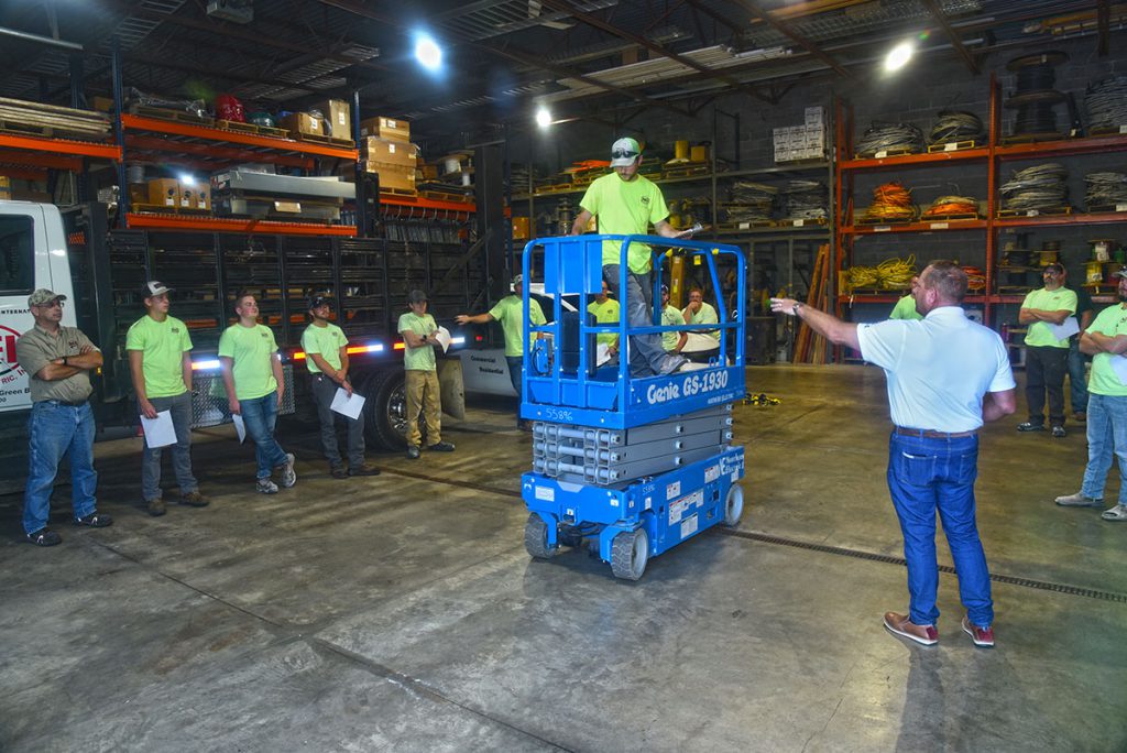 A group of NEI electricians gathered in the shop for a lift safety training session