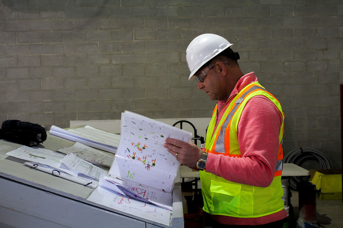 Jim Conard reviewing building plans while on a job site