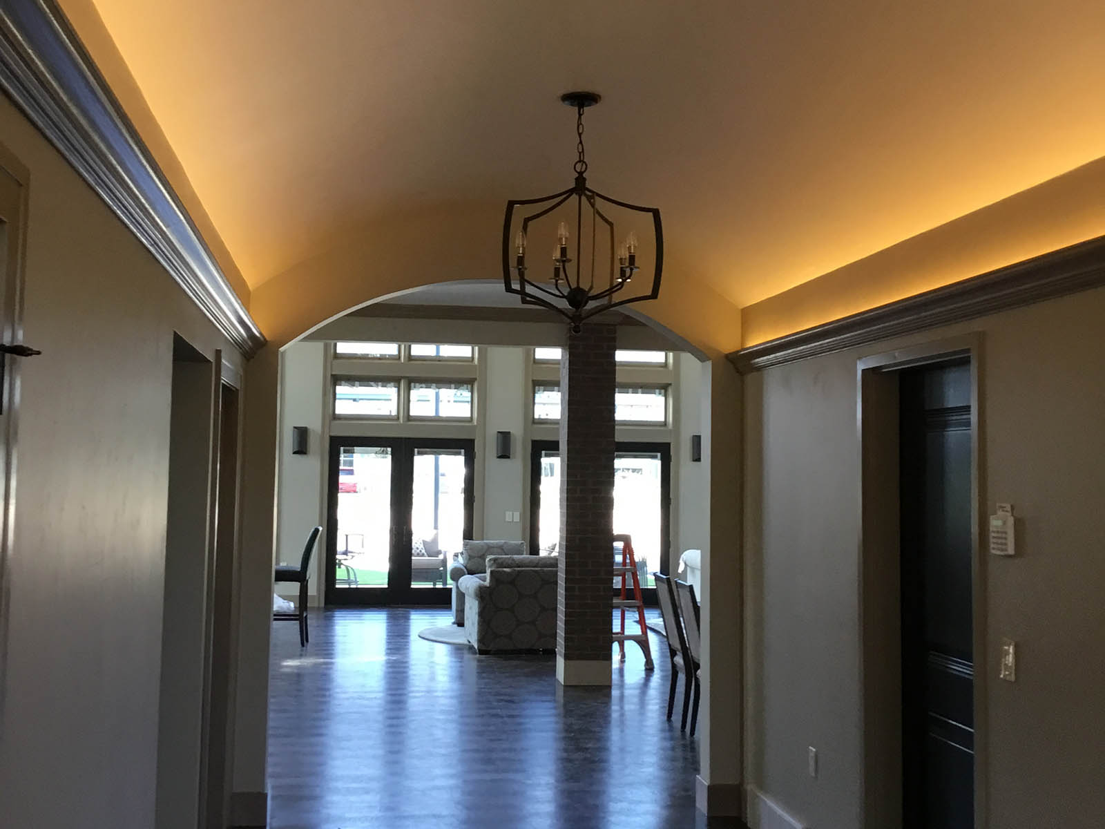 Hallway with hidden crown molding lighting and overhead hanging light