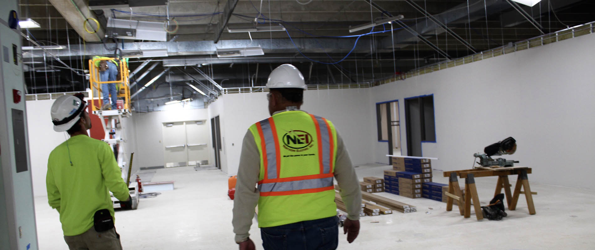 NEI COO Jim Conard walking through job site with another electrician