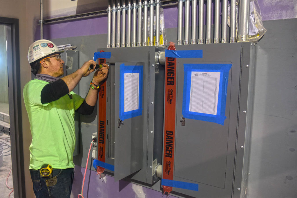 An NEI electrician opening up an electrical panel