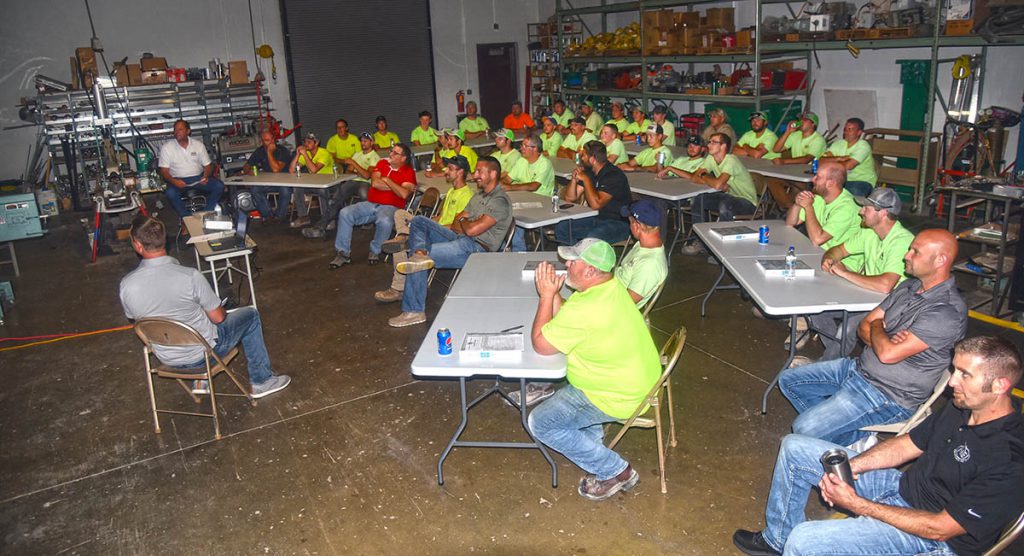 A group of NEI electricians gathered in the shop for a safety training session