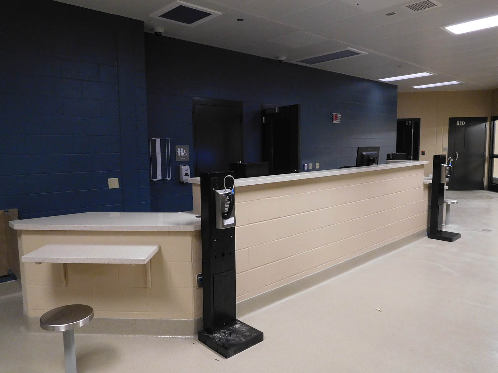 common area at the Oconto County Law Enforcement Center with bathrooms and benches with phones