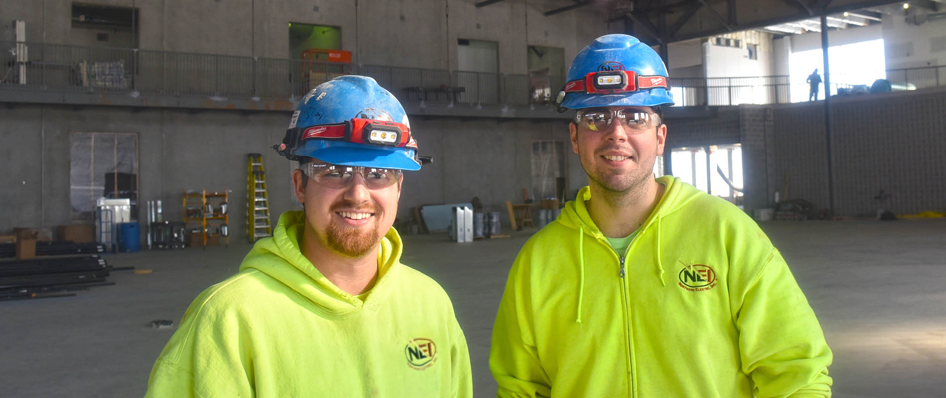 Two NEI electricians at the Keshena Family Engagement Center job site
