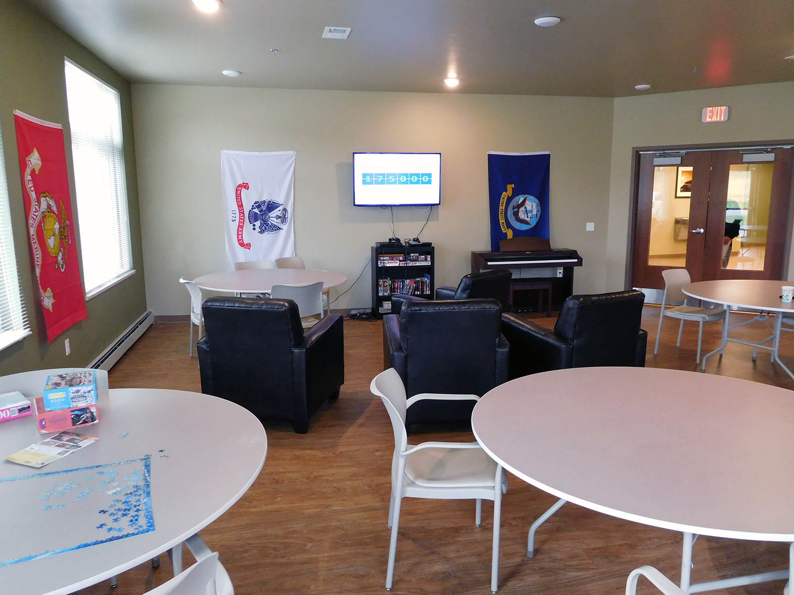 community room with TV, video games, movies, piano, lounging area and tables and chairs for sitting